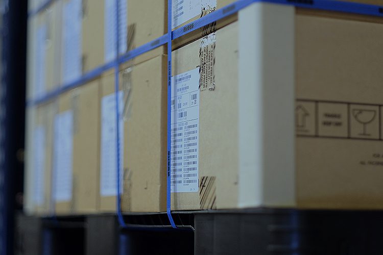 Stacked cardboard boxes with blue straps.